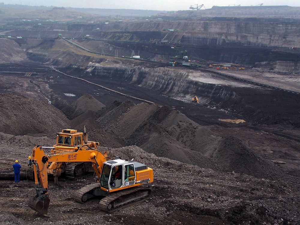 Large-scale mining operation with excavator and open-pit mine